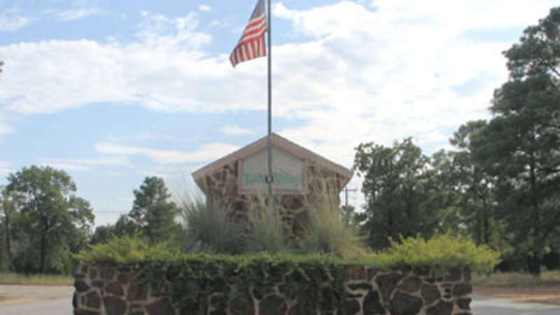 Tahitian Village entrance sign with American flag near Bastrop, Texas